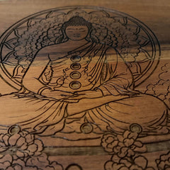 Wooden carving of a seated Buddha figure with floral patterns on a wooden background