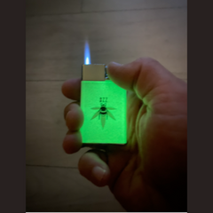Hand holding a lighter with a glowing green label against a wooden background